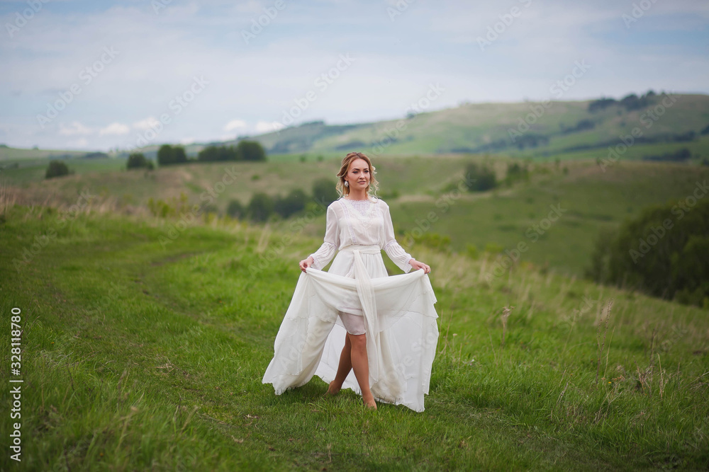 the bride walks in the field against the backdrop of the mountain the bride walks in the field against the backdrop of the mountain