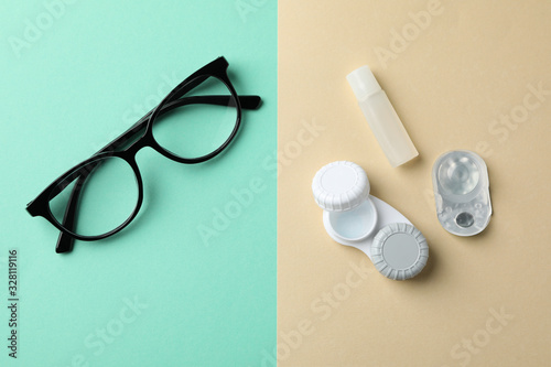 Glasses and contact lenses on two tone background  top view