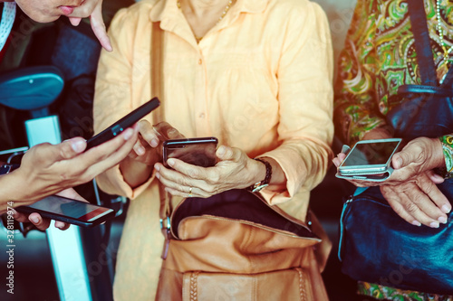 Elderly women learn how to use applications related to language translation from young men. While traveling abroad at the airport.