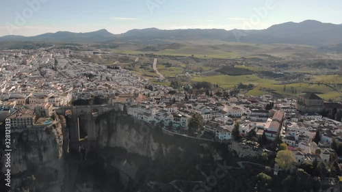 Aerial view of an ancient Spanish city Ronda in Andalucia. Drone flying over the famous bridge Puente Nuevo connecting the two parts of the Old Town, the Plaza de Toros (Bulls square) .