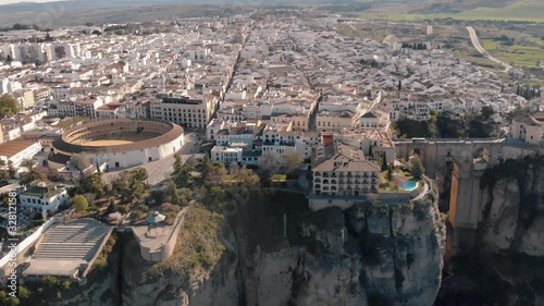 Aerial view of an ancient Spanish city Ronda in Andalucia. Drone flying over the famous bridge Puente Nuevo connecting the two parts of the Old Town, the Plaza de Toros (Bulls square) .