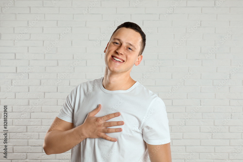 Handsome young man near white brick wall Handsome young man near white brick wall
