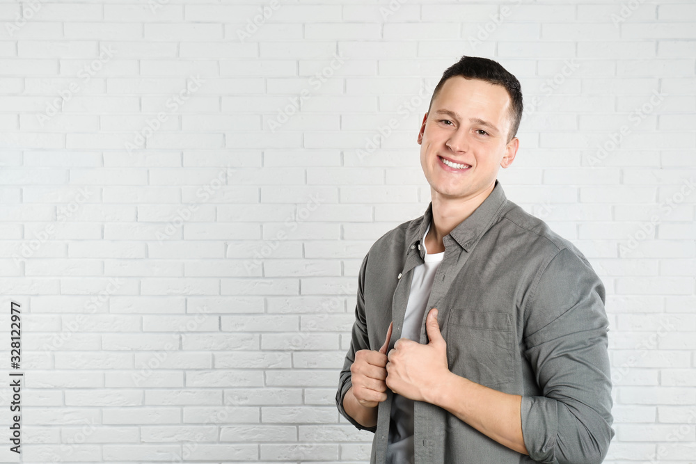 Handsome young man near white brick wall. Space for text Handsome young man near white brick wall. Space for text