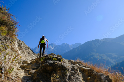 Trekker hiking with trekking pole on the mountain in Yunnan, China.
