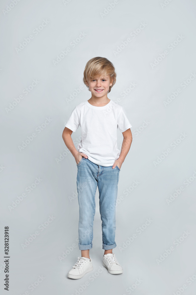 Cute little boy in casual outfit on light grey background Cute little boy in casual outfit on light grey background