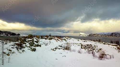 décollage en drone dans la neige à côté du pont de sommaroy en Norvège du nord au coucher du soleil sous les nuages menaçants de la tempête de neige