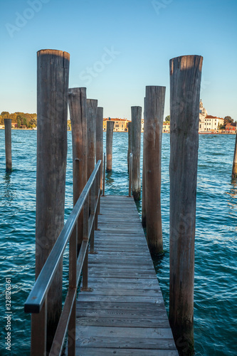 Pier wooden poles tightened together by rusty chains on canal in Venice © k_samurkas