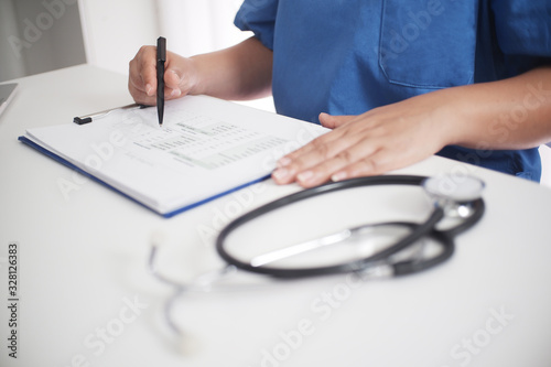 Doctor's working table. Focus on stethoscope. Female medicine doctor operating on background. Healthcare and medical concept Copy-space