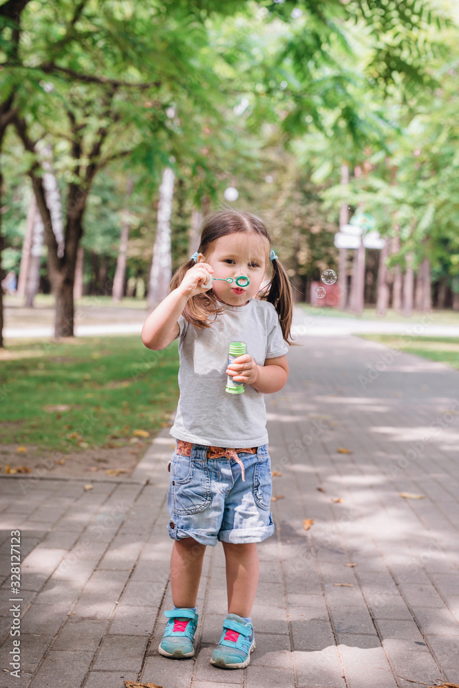 Child blowing a soap bubbles in summer park Child blowing a soap bubbles in summer park