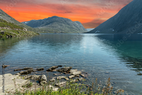 Mountain lake landscape with red sunset sky, Norway, road to Dalsnibba mountain from Geiranger. photo