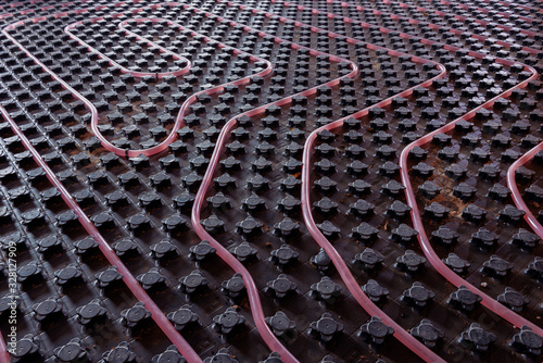 Underfloor heating system installation. Close up on water floor heating system interior of a new residential building. Pipes filled with propylene glycol. Individual Heating.