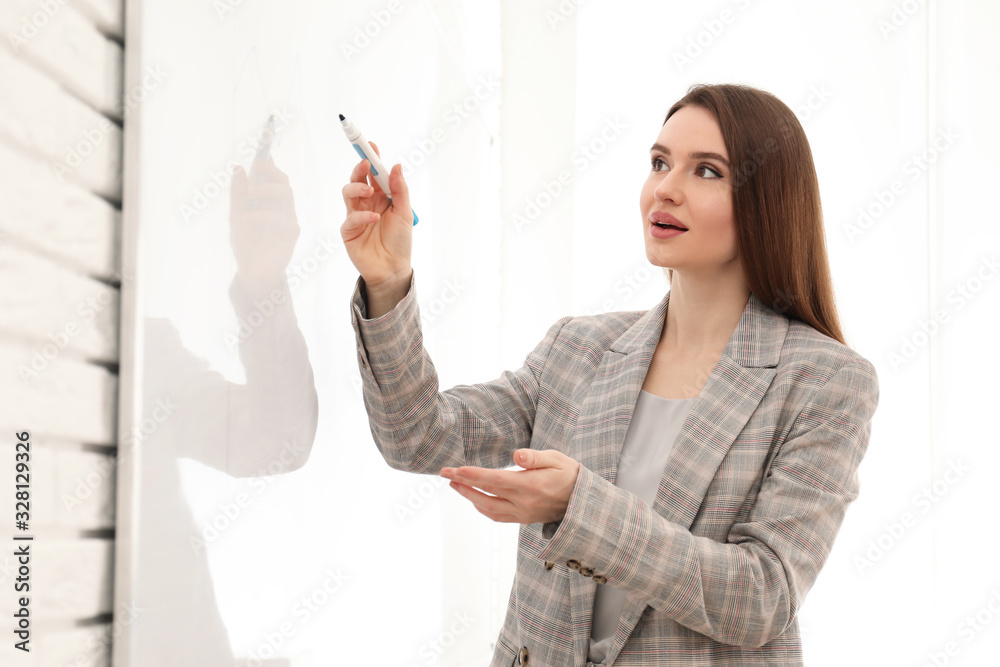Professional business trainer near whiteboard in office Professional business trainer near whiteboard in office