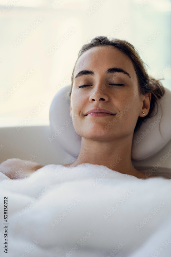 Close-up of young woman relaxing while taking a bath in bathtub Close-up of young woman relaxing while taking a bath in bathtub