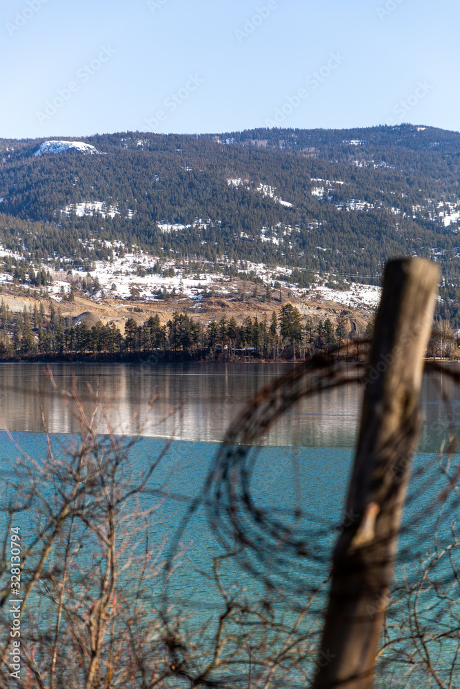 View over calm lake with old wire fence View over calm lake with old wire fence