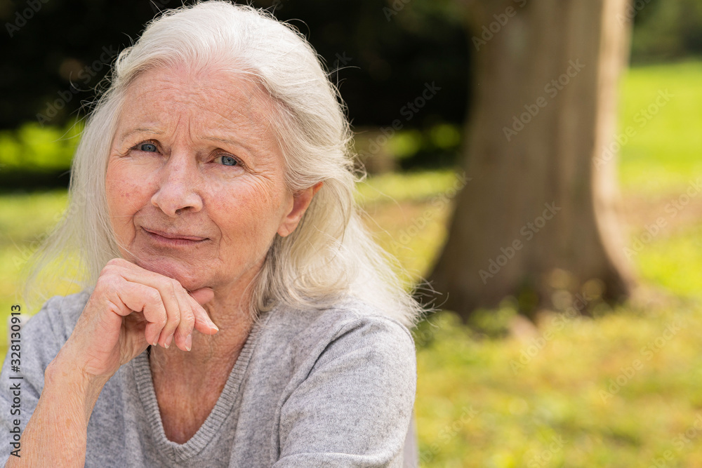 Portrait of smiling senior woman sitting in garden Portrait of smiling senior woman sitting in garden