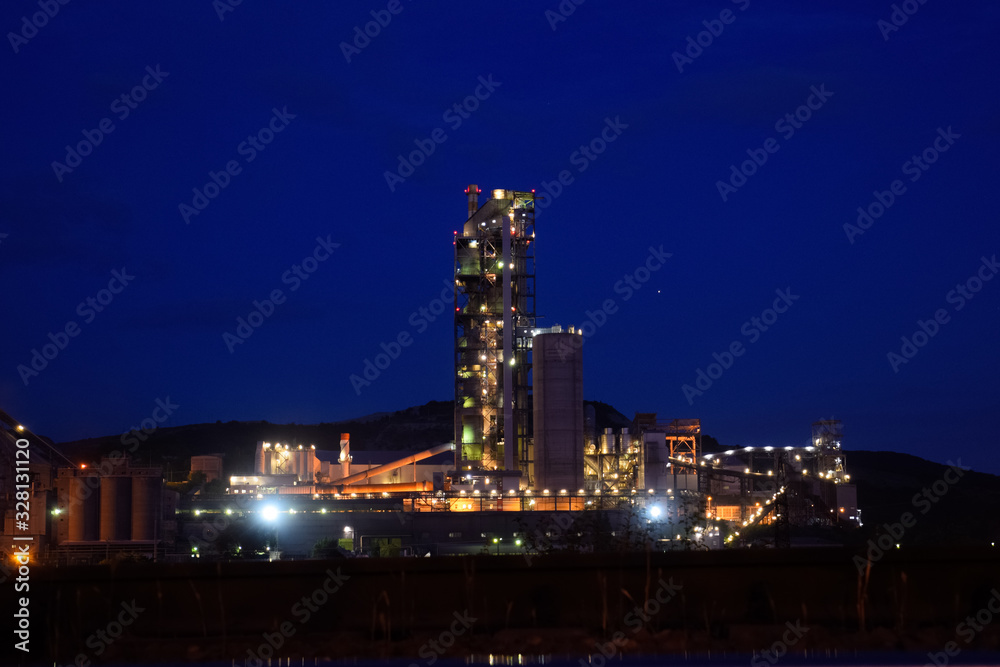 building of a cement plant at night, the lights of a lamp lighting a factory. Industrial facility.