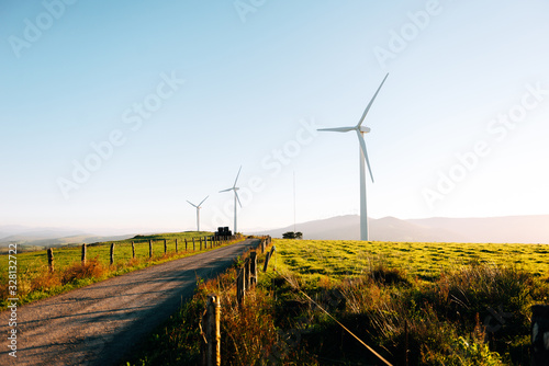 Wind turbines on beautiful sunny summer. road through mountain Eolic park. Green ecological power energy generation. Wind farm eco field. clean energy concept.