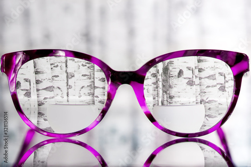 Eyeglasses Glasses with Bifocals and Black pink Frame smudged agaist birch trees photo