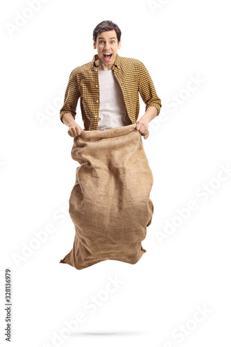 Excited young man playing a sack race