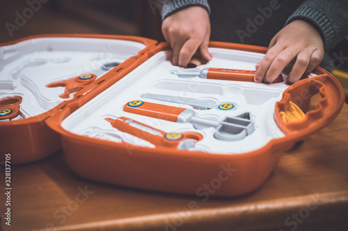 Kids hands on a toy medical briefcase