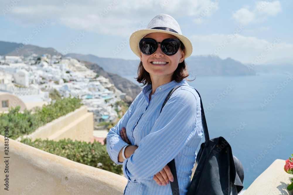 Happy mature woman tourist traveling on famous island Santorini