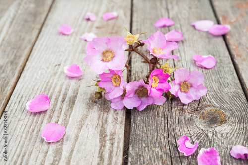 Fototapeta Naklejka Na Ścianę i Meble -  Pink Flowers and Petals on rustic old wooden table. Vintage Floral background.
