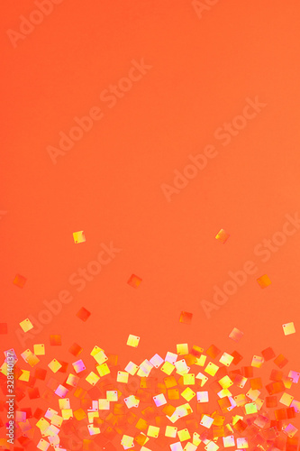 Flying shining square neon confetti at festive orange background with copy space. Lush lava color 2020.