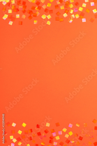 Festive orange background with shining square neon confetti and copy space. Lush lava color 2020.