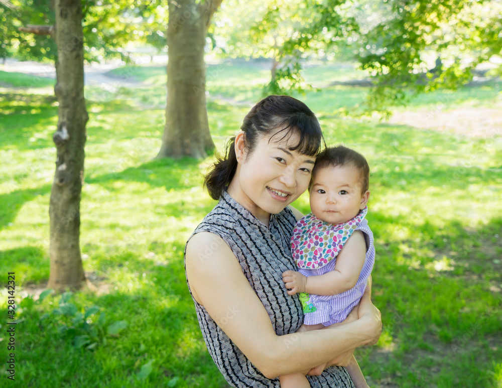 Interracial family portrait: Asian mother and baby in park Interracial family portrait: Asian mother and baby in park
