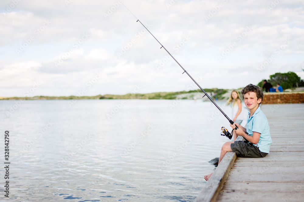 Young boy fishing from the edge of a dock Young boy fishing from the edge of a dock