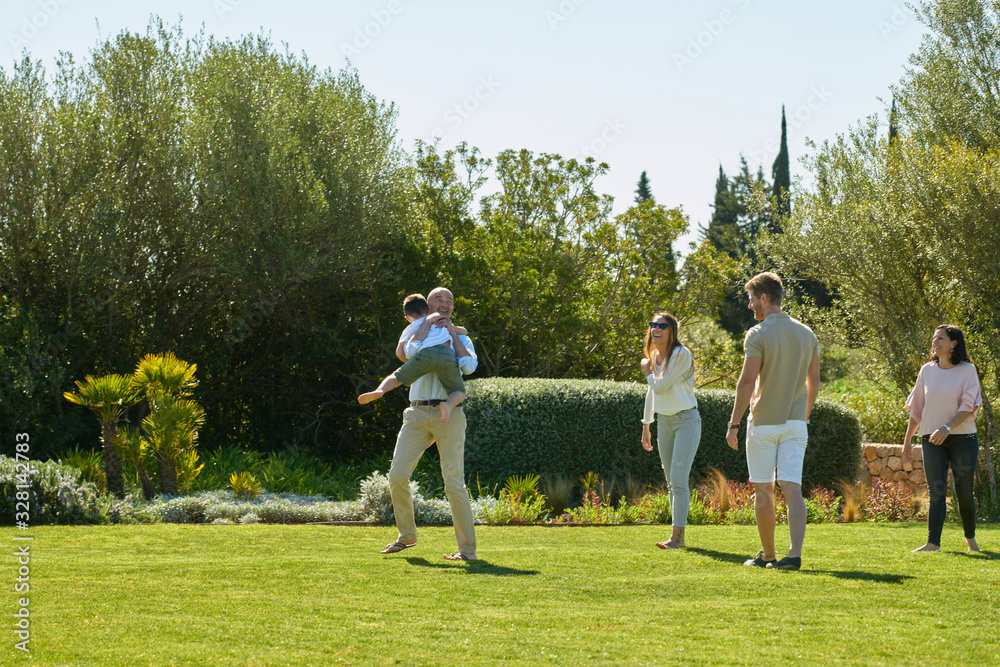 Group of people with kid in summer garden Group of people with kid in summer garden