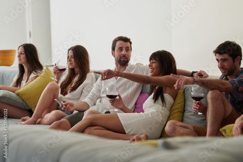 Best friends sitting on sofa watching tv.