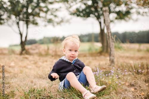 toddler sitting in the grass photo