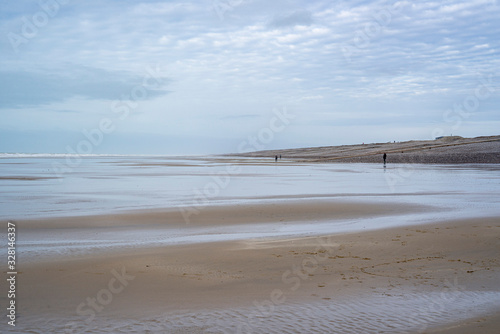 Caux. Somme. France. plage de sable    mar  e basse. Des personnes au loin se prom  nent sur le sable.