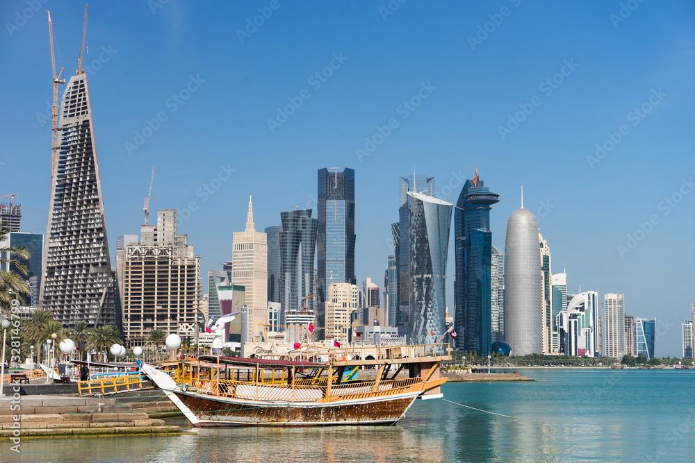 Fototapeta premium Skyscrapers in the city center with water and boat foreground of Doha, Qatar 2020.