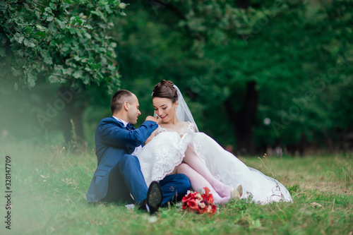 The bride in a beautiful dress the groom stylishly dressed. Bride and groom in garden on their wedding, photo session.