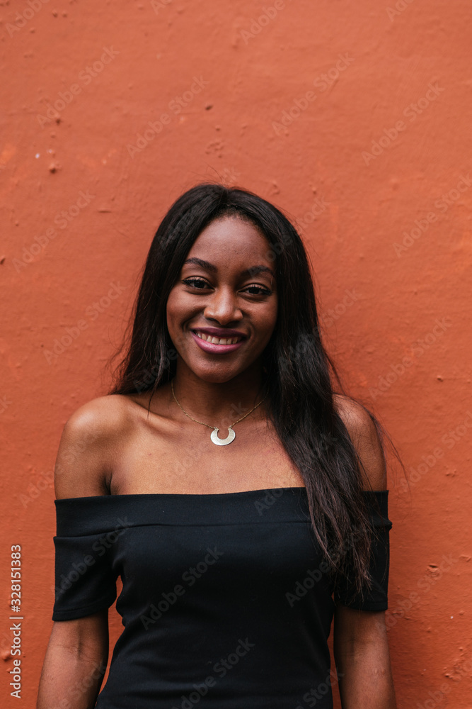 Portrait, Pretty african woman with long hair smiling and lookin Portrait, Pretty african woman with long hair smiling and lookin