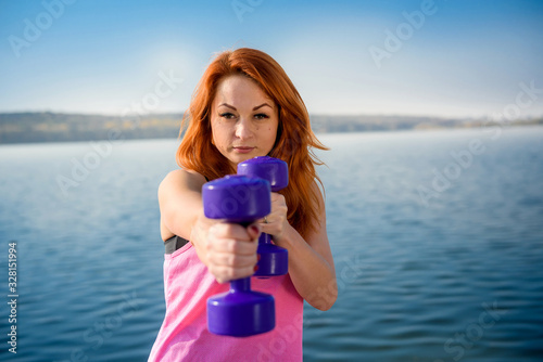 fitness training - beautiful young woman working exercise with dumbbells, as a part of her lifestyle