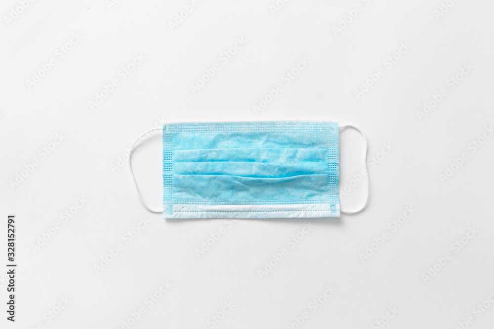 Fototapeta premium Medical mask on a gray background, view from above. Protection against germs and viruses concept