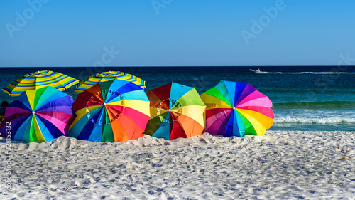bright multi color beach umbrellas on sand