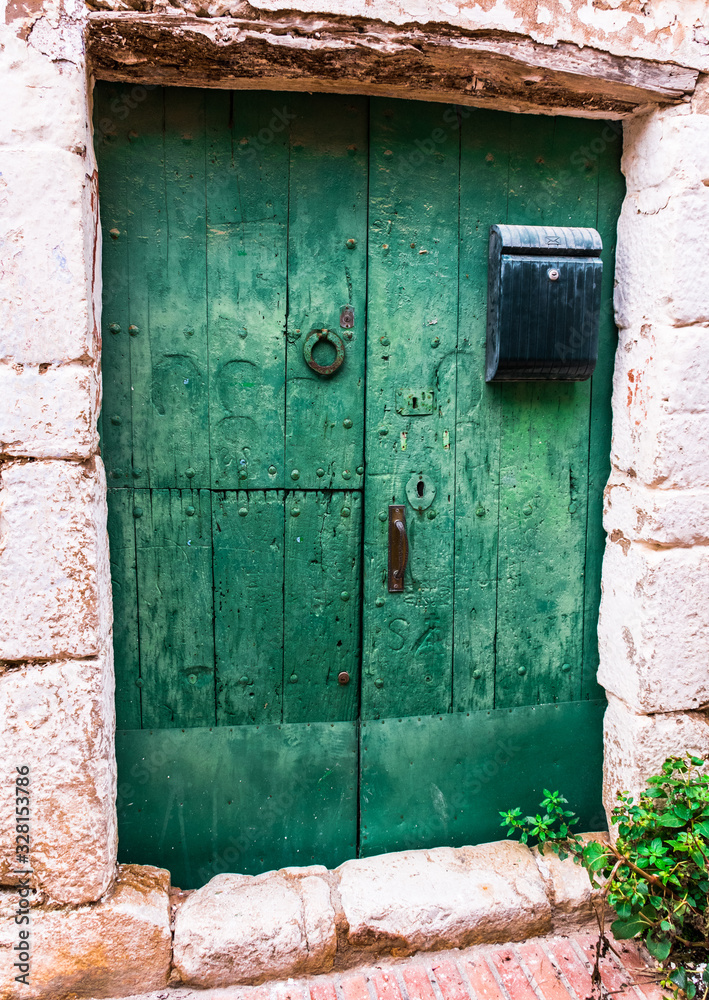 Rustic green wooden door, old of a house of the village of Sant Martin de Empuries
