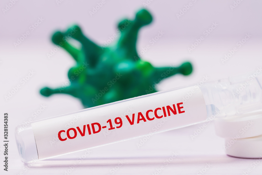 Obraz premium Ampoule with a vaccine from the new coronavirus COVID-19 with tablets on the table