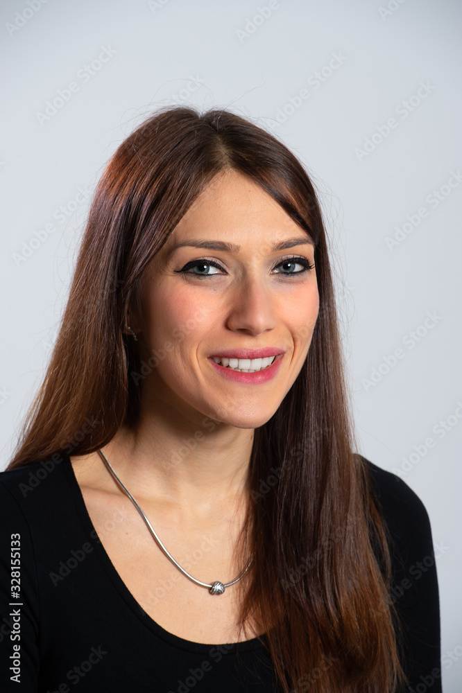Portrait of young smiling girl. Attractive brunette woman with long hair in black top looking at camera. Isolated caucasian person with make-up over white background. Portrait of young smiling girl. Attractive brunette woman with long hair in black top looking at camera. Isolated caucasian person with make-up over white background.