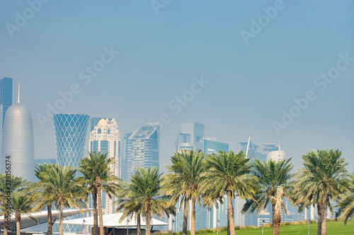 Panoramic view of modern skyline of Doha with Palms foreground. Concept of healthy environment © Hladchenko Viktor