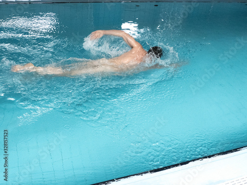 Nude man swimming in the pool