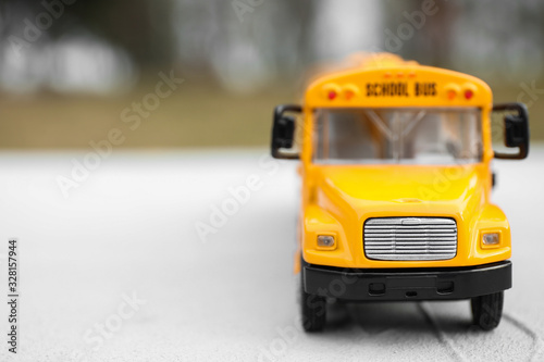 Closeup view of yellow toy school bus outdoors, space for text. Transport for students