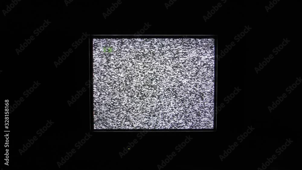 In the dark room the TV is lit. TV static screen with noise grain background