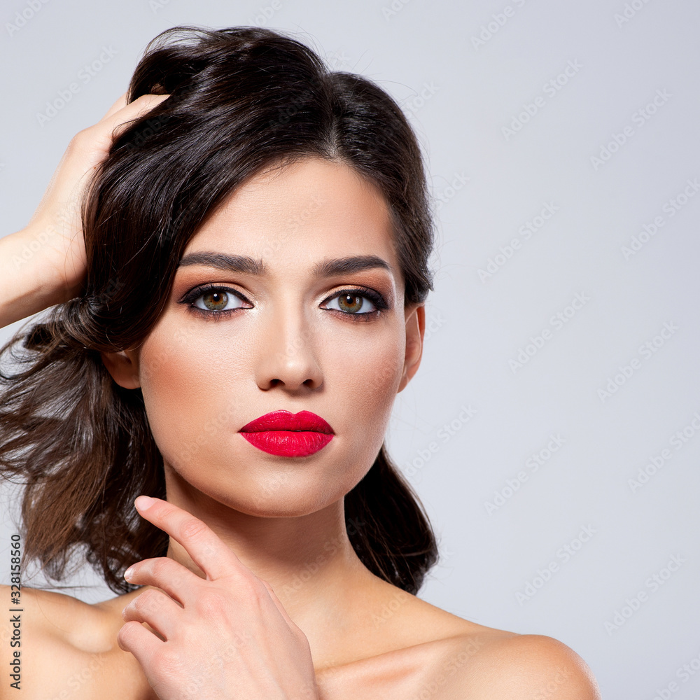Beautiful young fashion woman with red lipstick. Brunette woman with a clean skin of face. Portrait of model with bright red lips. Glamour fashion model with bright gloss make-up posing at studio. Beautiful young fashion woman with red lipstick. Brunette woman with a clean skin of face. Portrait of model with bright red lips. Glamour fashion model with bright gloss make-up posing at studio.