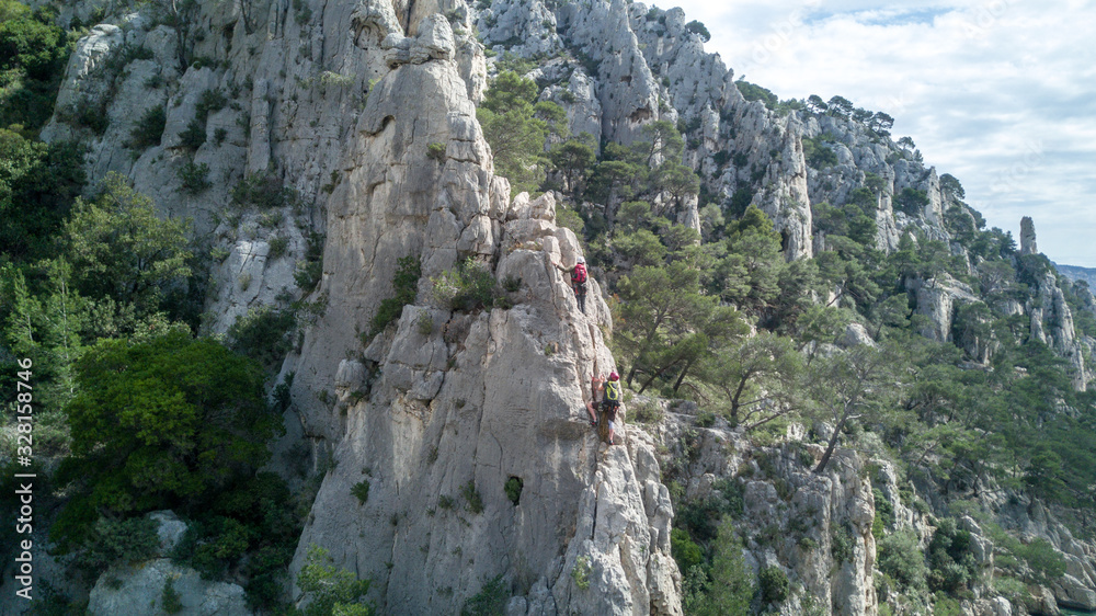 Young people climbing a rock formation in the south of france Young people climbing a rock formation in the south of france