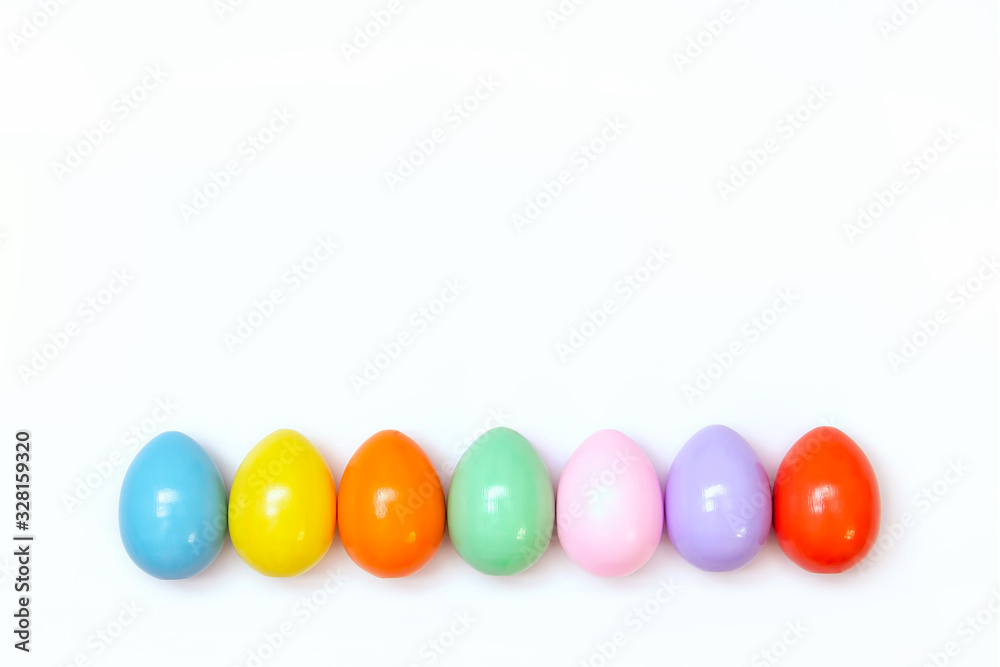 Top view of an Easter composition of painted eggs in bright juicy colors on a white background with a glossy texture. Holiday concept, flat layout, minimalism Top view of an Easter composition of painted eggs in bright juicy colors on a white background with a glossy texture. Holiday concept, flat layout, minimalism
